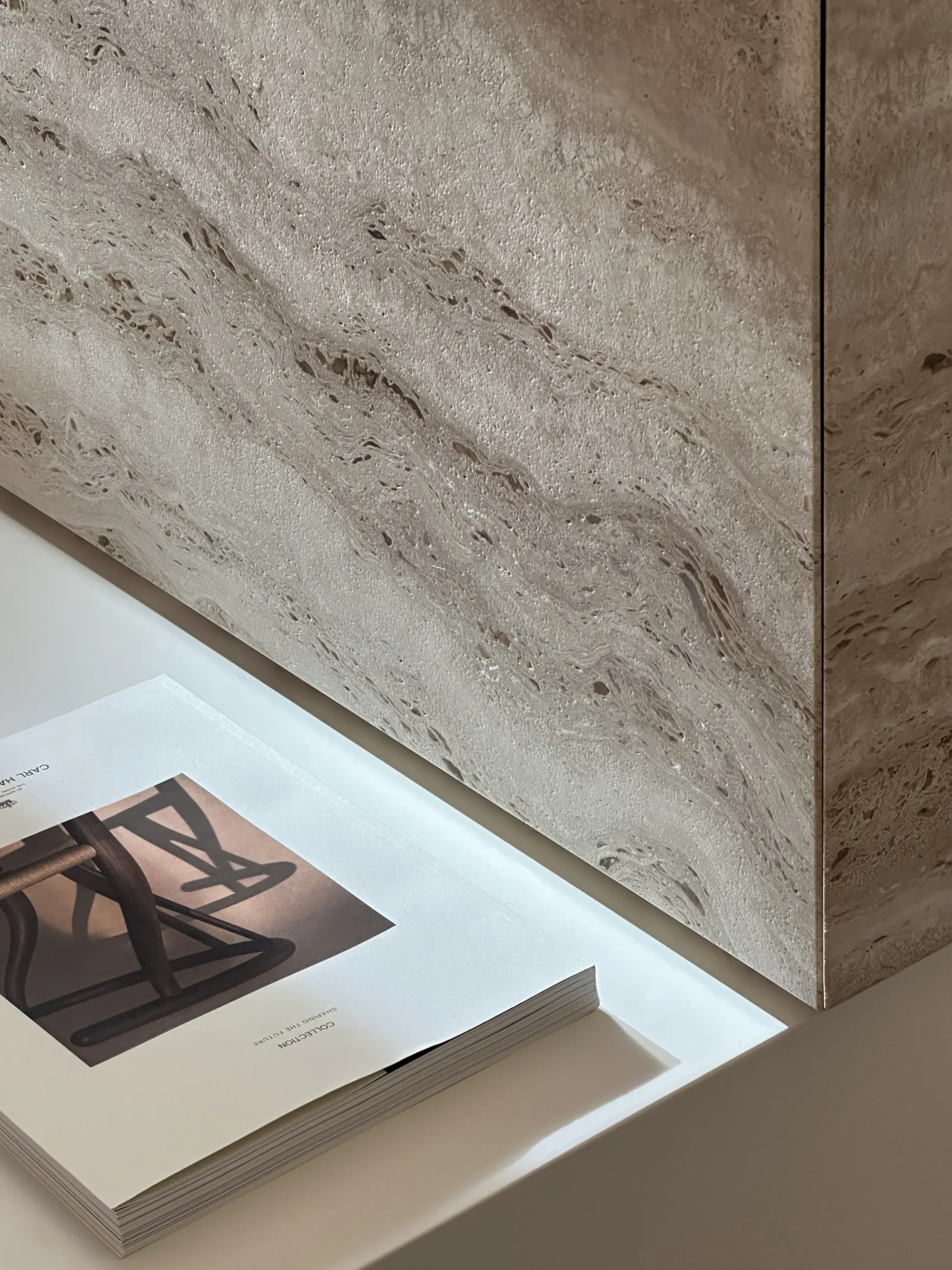Campione di travertino accostato a una superficie laccata nello showroom Origo